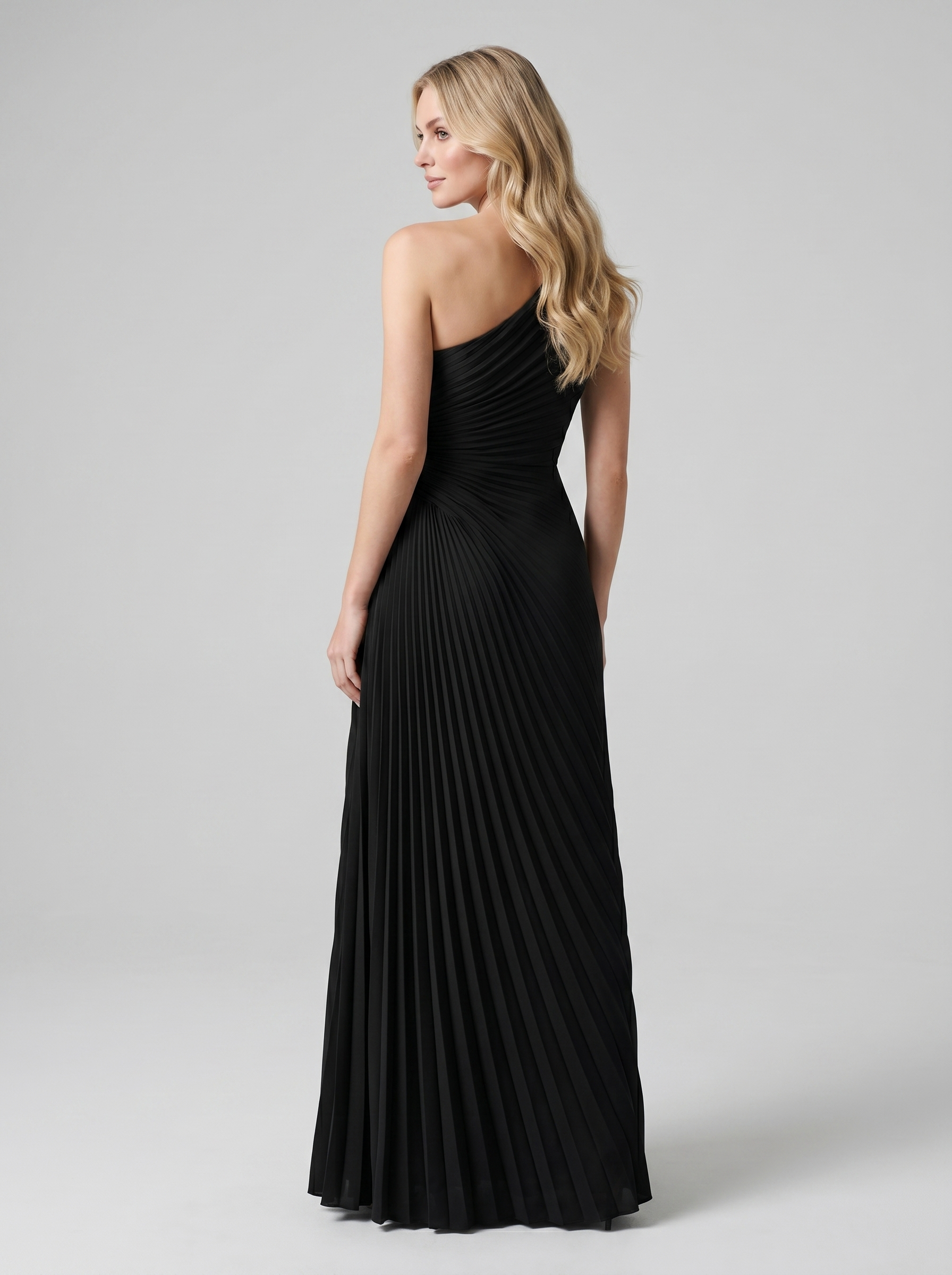 Black one-shoulder pleated maxi dress, back view showing bare shoulder and full-length skirt
