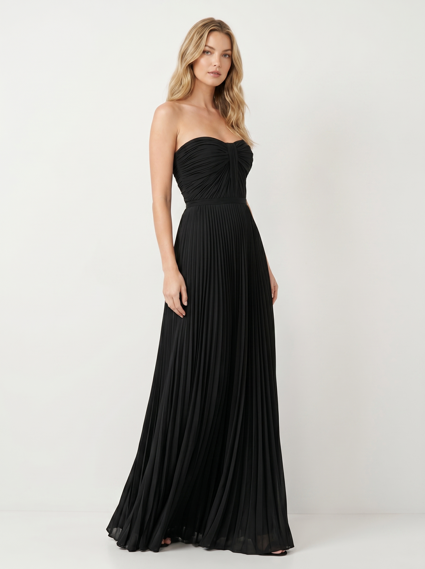Black strapless pleated maxi dress, three-quarter view showing pleated skirt and long silhouette