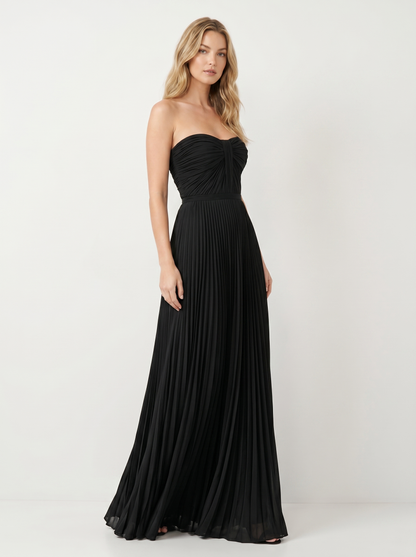 Black strapless pleated maxi dress, three-quarter view showing pleated skirt and long silhouette