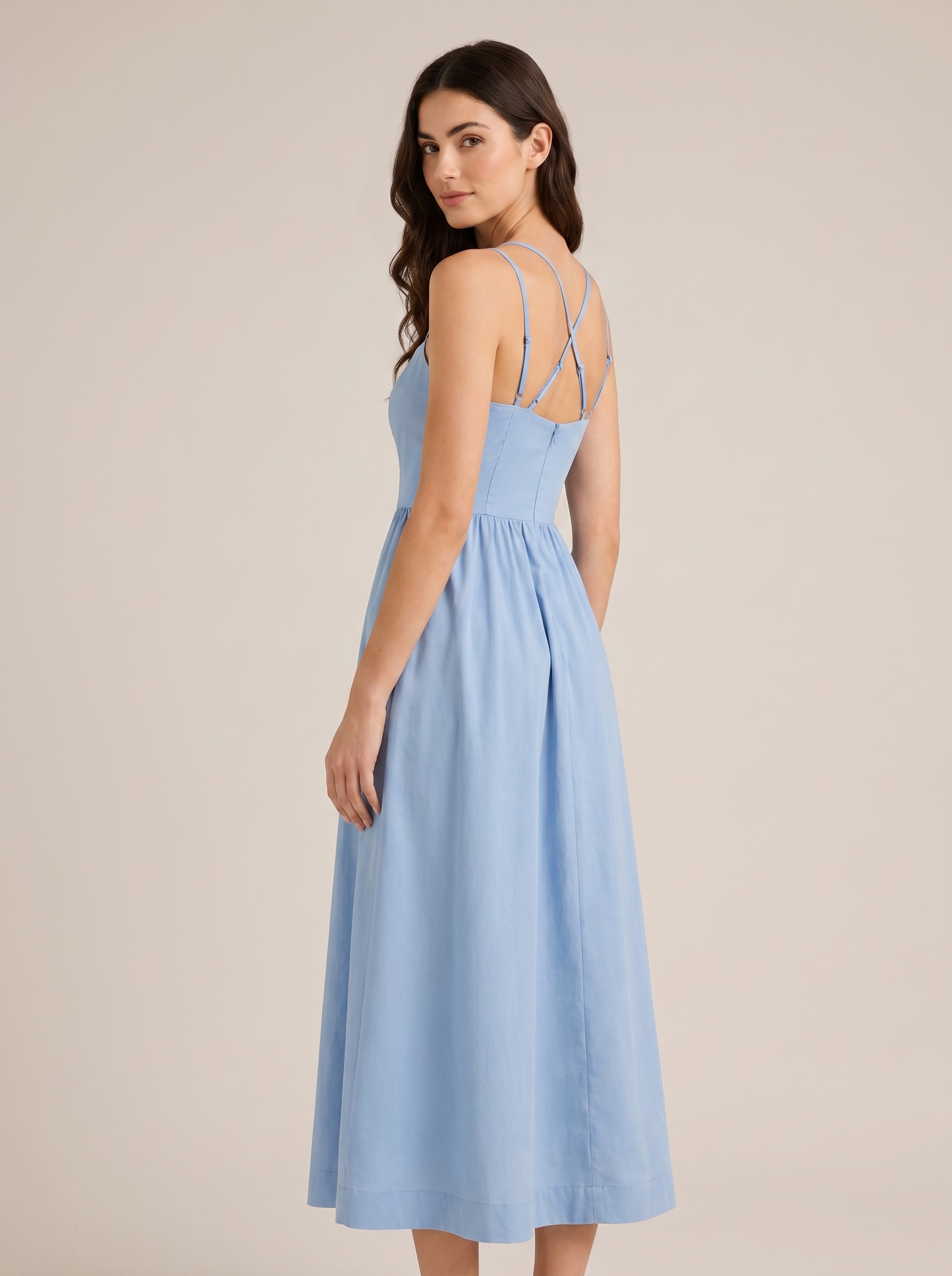 Blue A-line wedding guest midi dress, back view showing strappy bodice and full skirt on model