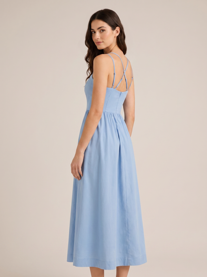 Blue A-line wedding guest midi dress, back view showing strappy bodice and full skirt on model
