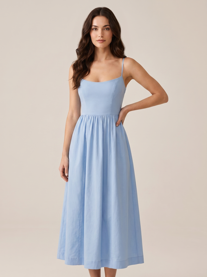 Blue A-line wedding guest midi dress with thin straps and fitted bodice, front view on model