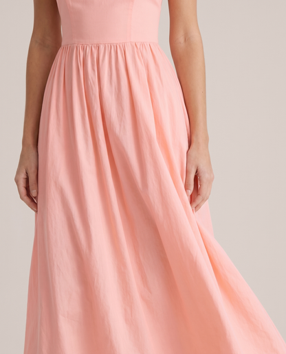 Close-up of pink A-line midi dress waist seam and flowing skirt showing soft fabric texture