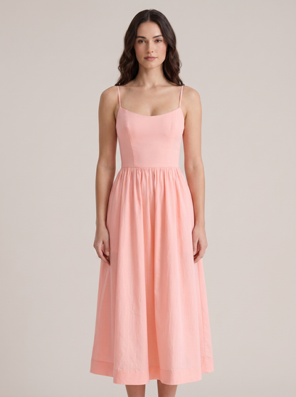 Pink A-line wedding guest midi dress with thin straps and fitted bodice, front view on model