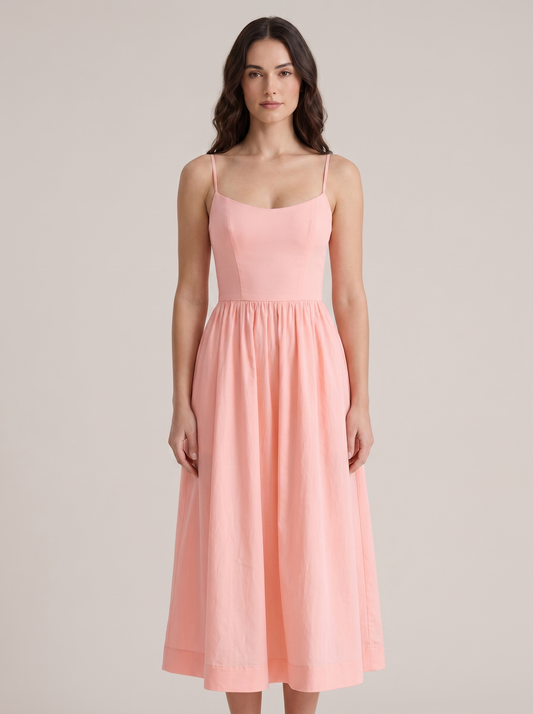 Pink A-line wedding guest midi dress with thin straps and fitted bodice, front view on model