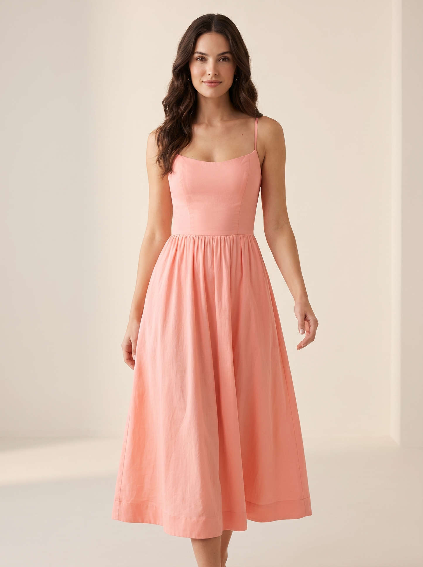 Pink A-line wedding guest midi dress, full-length view of model in a bright studio setting