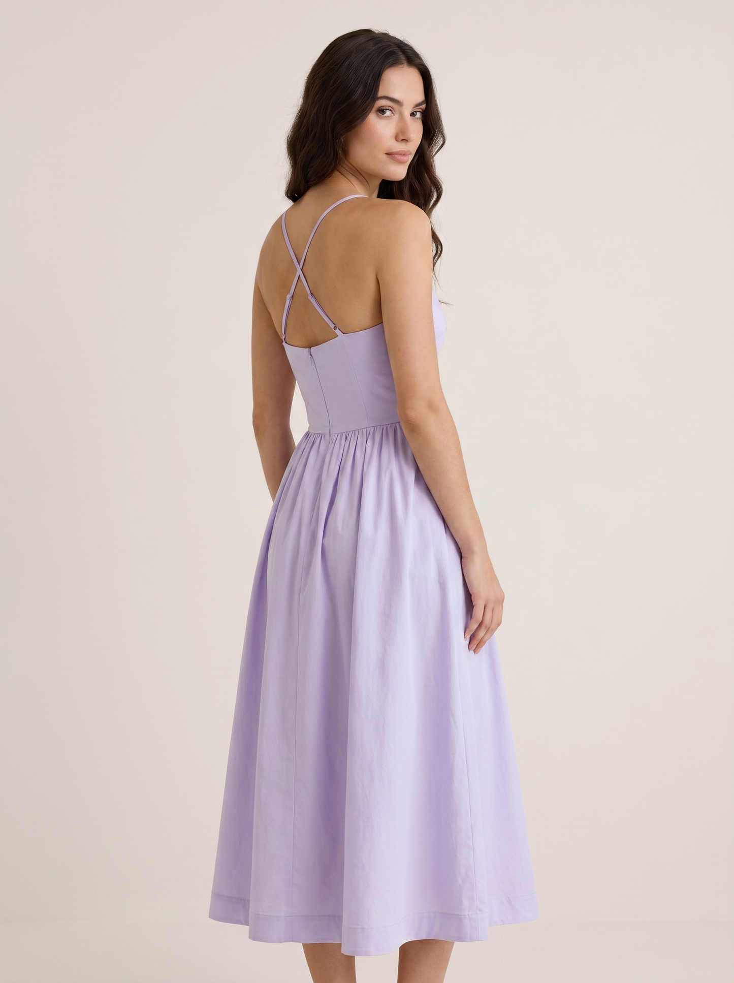 Purple A-line wedding guest midi dress, back view showing strappy bodice and full skirt on model