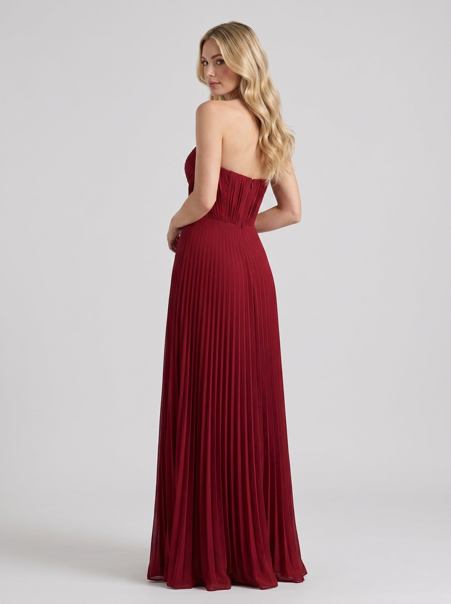 Red strapless pleated maxi dress, back view showing strapless bodice and full-length pleated skirt
