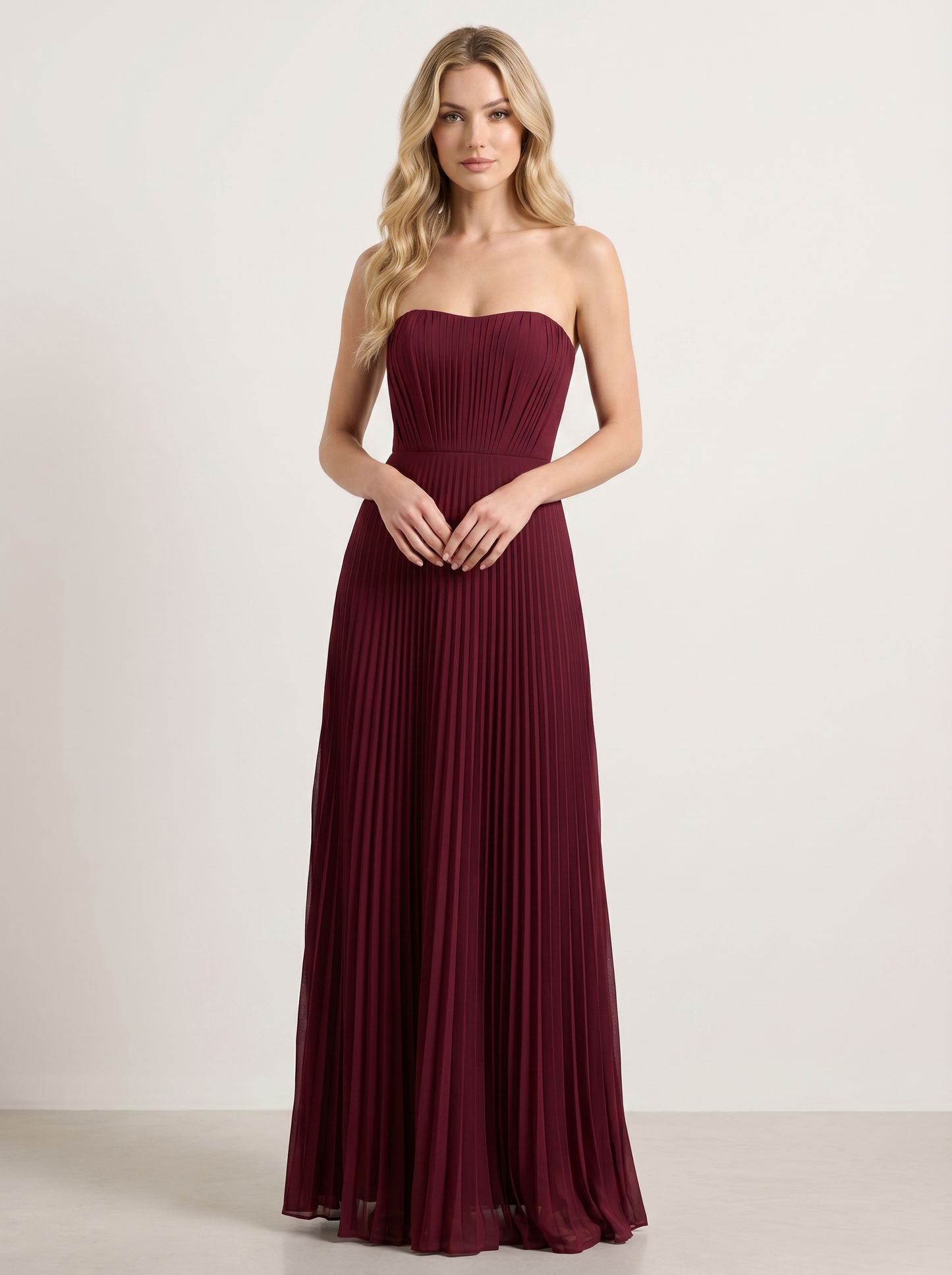 Red strapless pleated wedding guest maxi dress with structured bodice, front view on model