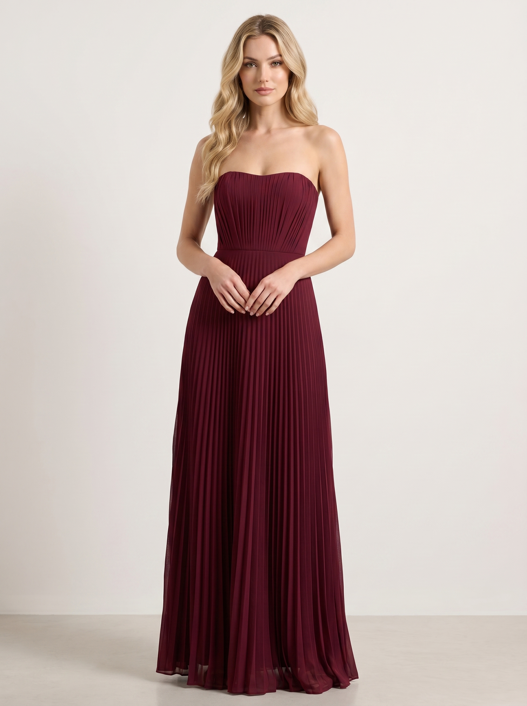 Red strapless pleated wedding guest maxi dress with structured bodice, front view on model