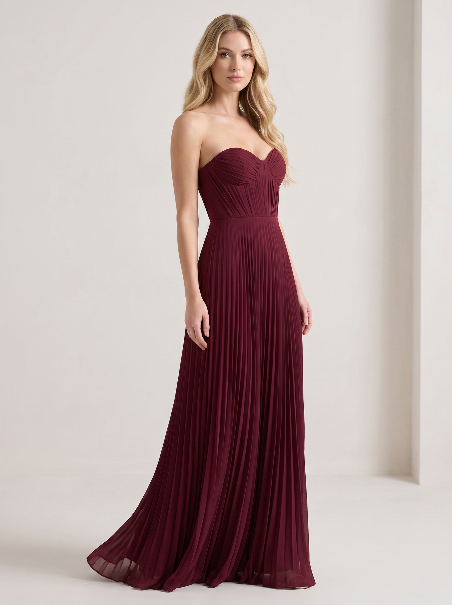 Red strapless pleated maxi dress, three-quarter view showing pleated skirt and long silhouette