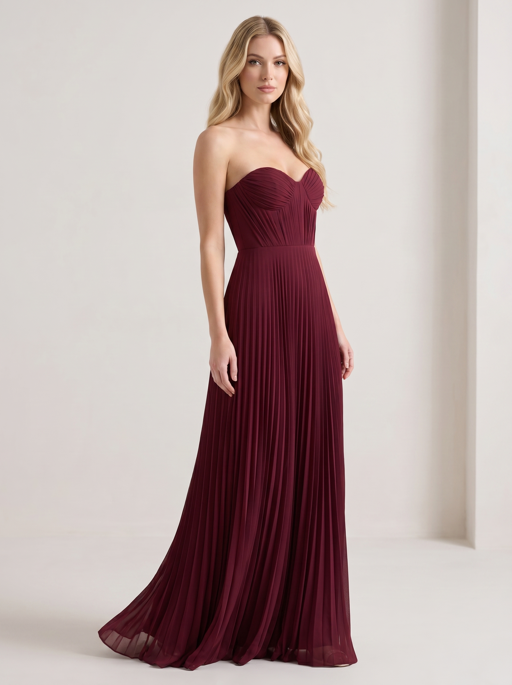 Red strapless pleated maxi dress, three-quarter view showing pleated skirt and long silhouette