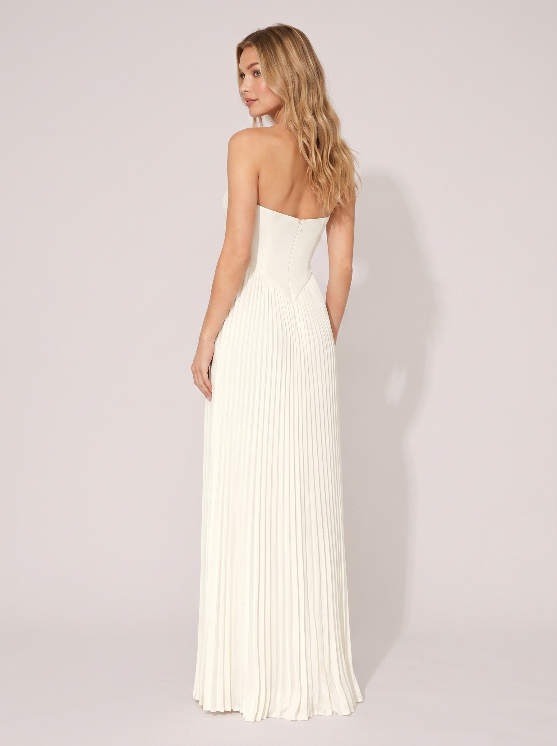 White strapless pleated maxi dress, back view showing strapless bodice and full-length pleated skirt