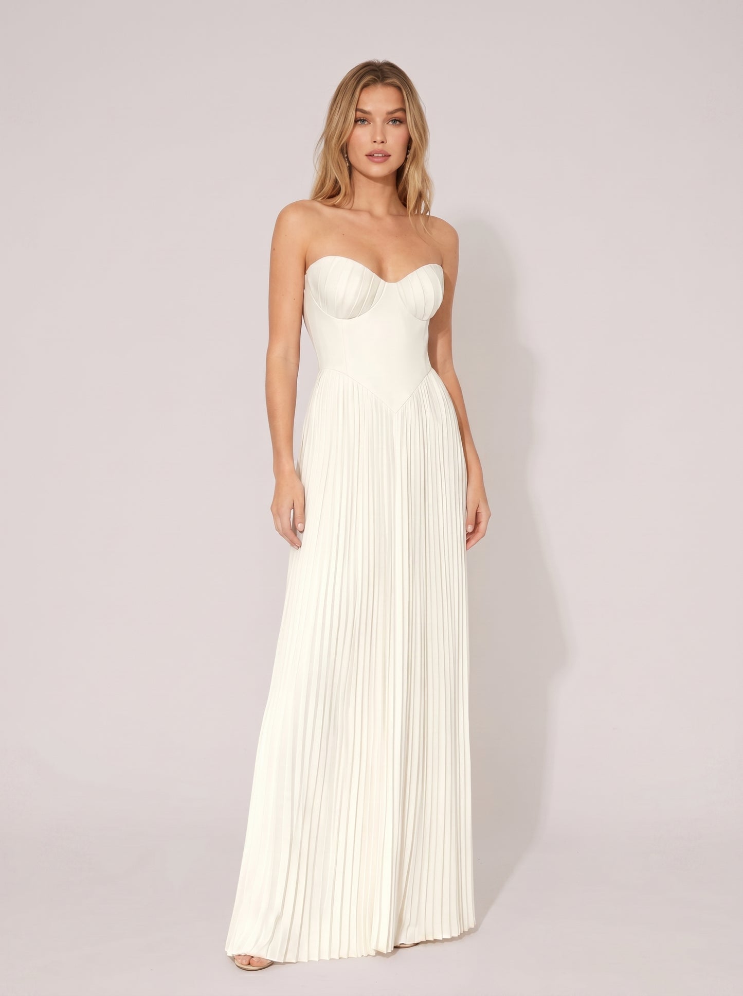 White strapless pleated wedding guest maxi dress with structured bodice, front view on model