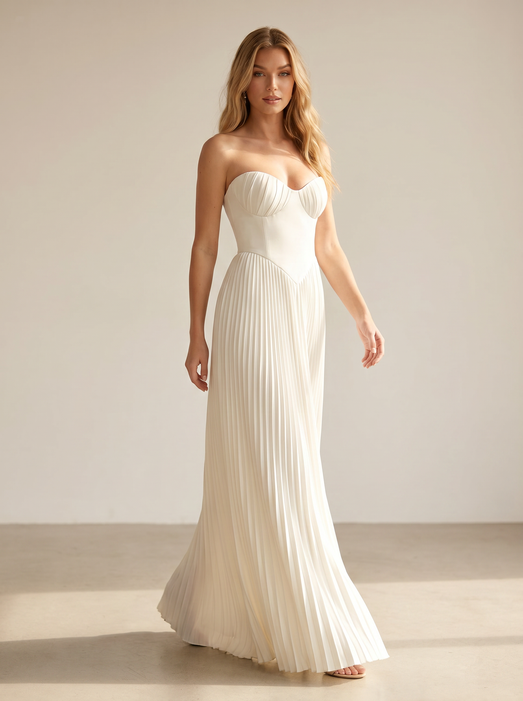 White strapless pleated maxi dress, full-length view of model walking in a bright studio