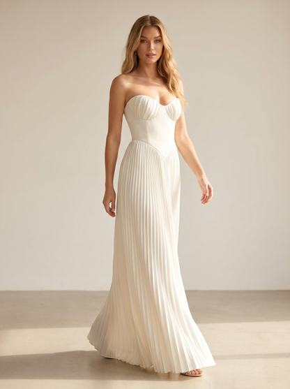 White strapless pleated maxi dress, full-length view of model walking in a bright studio