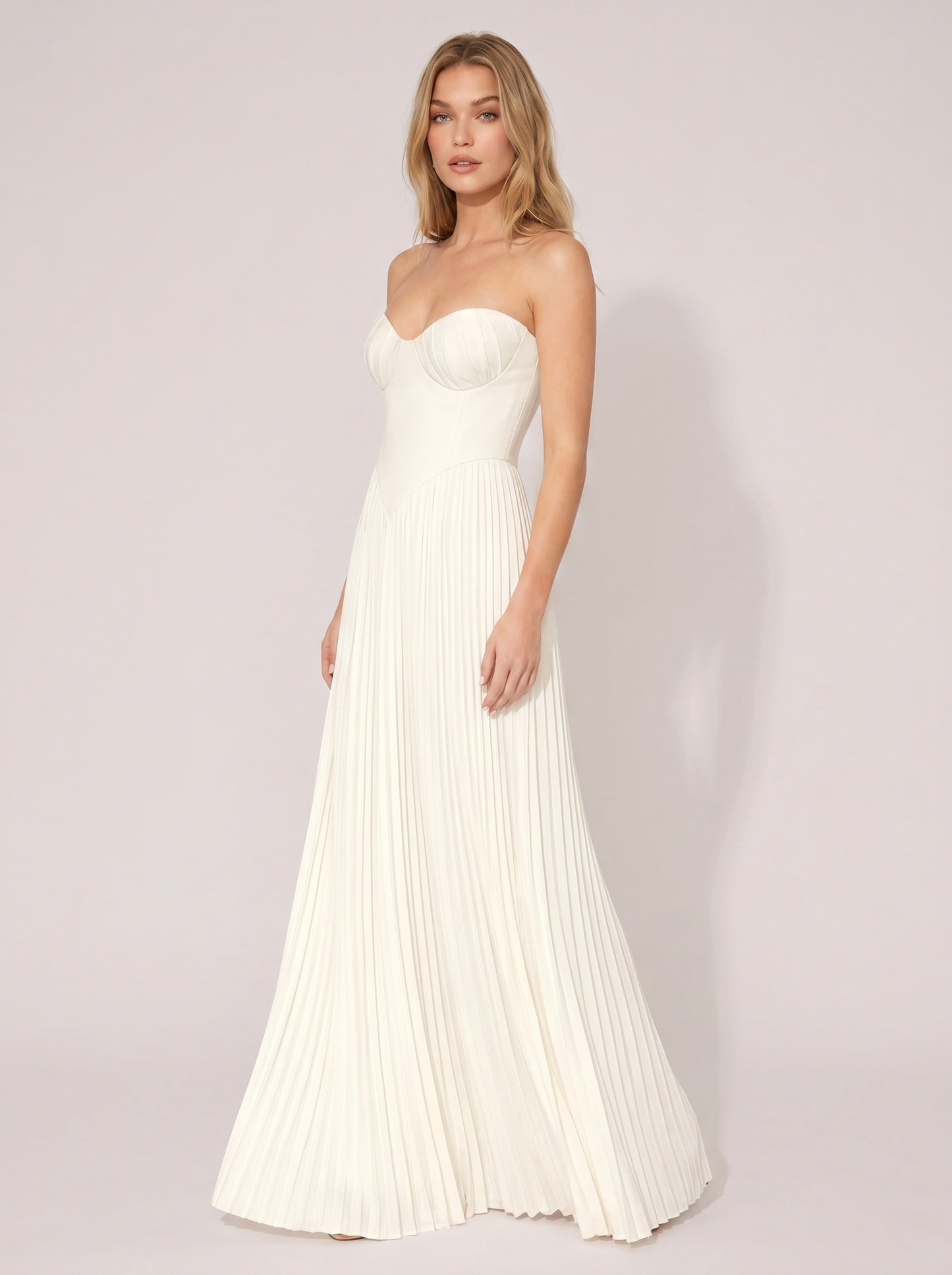 White strapless pleated maxi dress, three-quarter view showing pleated skirt and long silhouette