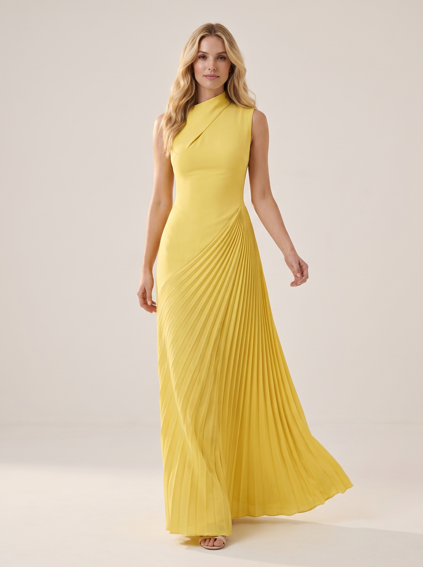 Yellow one-shoulder pleated maxi dress, full-length view of model walking in a bright studio